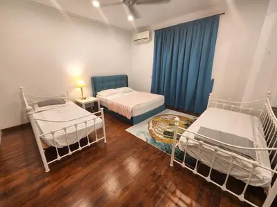 a room with two beds and a blue curtain at Solok Burma Vacation Home @ Gurney Penang in George Town