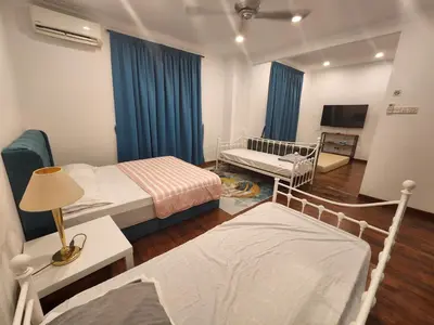 a small room with two beds and a television at Solok Burma Vacation Home @ Gurney Penang in George Town