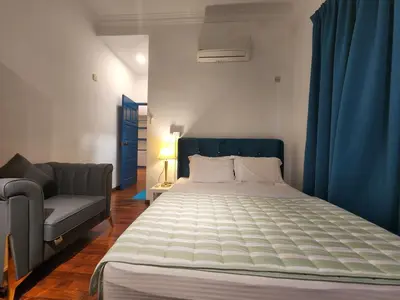 a bedroom with a large bed and a couch at Solok Burma Vacation Home @ Gurney Penang in George Town
