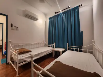 a room with two beds and a blue curtain at Solok Burma Vacation Home @ Gurney Penang in George Town