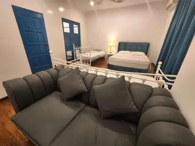 a living room with a couch and a bed at Solok Burma Vacation Home @ Gurney Penang in George Town
