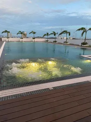 a swimming pool with water and palm trees in it at D Naurah Meritus Guesthouse in Perai