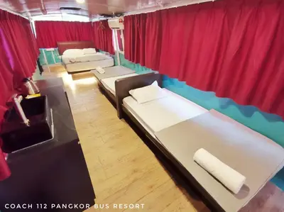 a room with three beds and a red curtain at Pangkor Bus Resort by BESLA in Pangkor