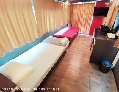 a small room with two beds and a desk at Pangkor Bus Resort by BESLA in Pangkor