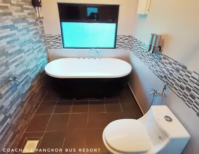 a bathroom with a tub and a toilet and a sink at Pangkor Bus Resort by BESLA in Pangkor