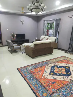 a living room with a couch and a rug at Villa Auliyya - MusleemHomestay in Kampong Sungai Leman
