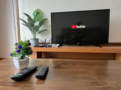two remote controls sitting on a table in front of a television at NEW 6pax 3BR Sunrise view 100m Attractive Places Kea Farm in Cameron Highlands