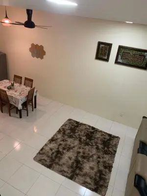 a dining room with a table and a rug at ZillQayyim Homestay in Seri Iskandar