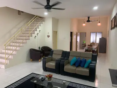 a living room with a couch and a staircase at ZillQayyim Homestay in Seri Iskandar