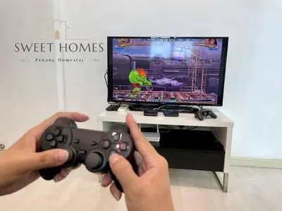 a person holding a video game controller in front of a tv at Pool View Stylish Suite at Jelutong Penang 1-4pax in George Town