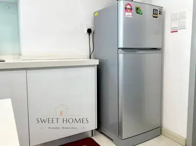 a silver refrigerator in a kitchen next to a counter at Pool View Stylish Suite at Jelutong Penang 1-4pax in George Town