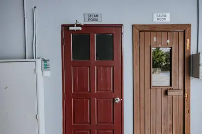 a red door and a wooden door next to a refrigerator at Ipoh Town Kinta Riverfront Apartment 7pax by Glamorous in Ipoh