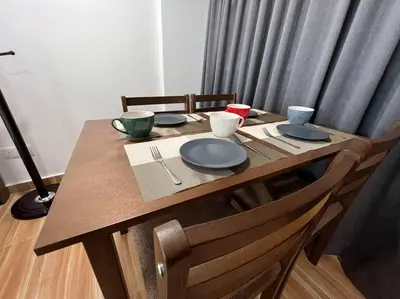 a wooden table with plates and bowls on it at NEW 6 PAX SUITE near USM and SPICE ARENA and AIRPORT in Bayan Lepas