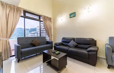 a living room with a couch and a table at Batu Ferringhi Sea View Penthouse Resort Home in Bayan Lepas