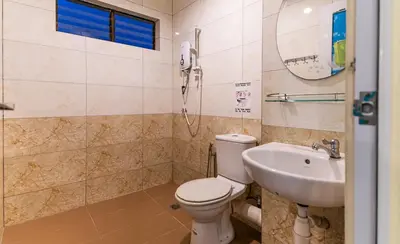 a bathroom with a toilet and a sink at Batu Ferringhi Sea View Penthouse Resort Home in Bayan Lepas