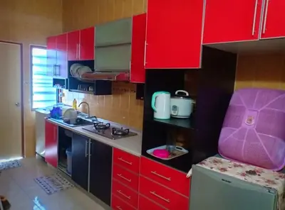 a small kitchen with red cabinets and a pink chair at Zulkifli Homestay Tambun,Ulu kinta,Tg Rambutan in Ipoh