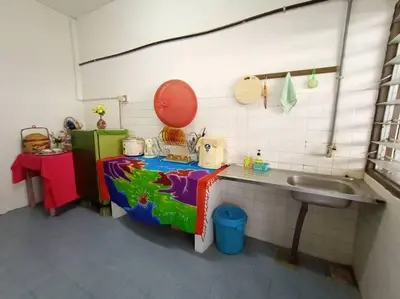 a small kitchen with a sink and a table at HEAWOOD GUEST HOUSE Sungai Siput in Sungai Siput