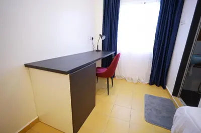 a desk in a room with a red chair at RENTIO HOTEL in Kulim