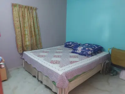 a bed with a quilt on it in a room at Rumah Kebun by Panorama Homestay in Lambor Kanan