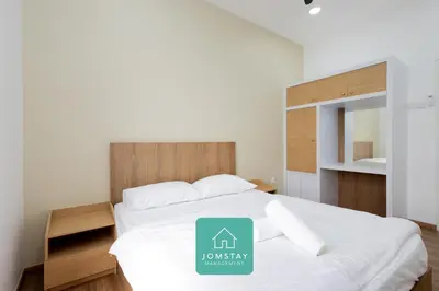 a bedroom with a white bed with a sign on it at Jomstay The Cove Ipoh Hillside Residence in Ipoh