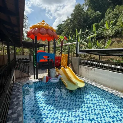a swimming pool with a slide and an umbrella at 15PAX 3 BR, Kids Swimming Pool, Pool table, BBQ near Spice ARENA, Airport Penang in Bayan Lepas