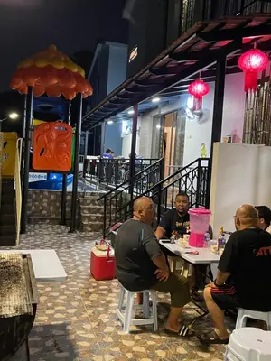 a group of people sitting at a table in a restaurant at 15PAX 3 BR, Kids Swimming Pool, Pool table, BBQ near Spice ARENA, Airport Penang in Bayan Lepas