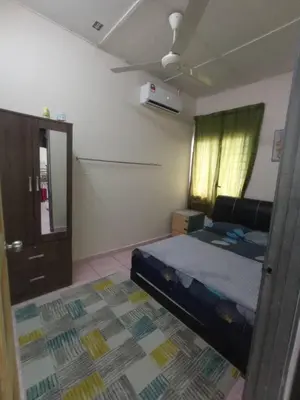 a bedroom with a bed and a door and a window at Rizki Homestay in Nibung Tebal