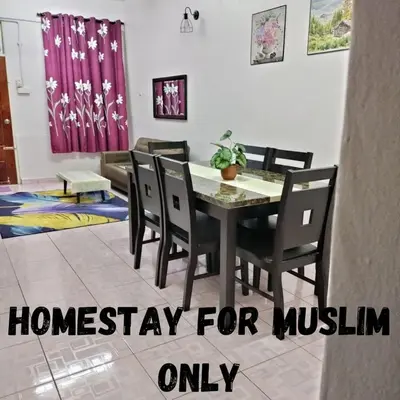 a dining room with a table and chairs at Rizki Homestay in Nibung Tebal