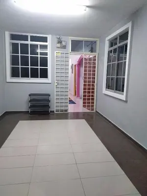a room with a white tile floor and windows at Rizki Homestay in Nibung Tebal