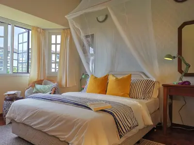 a bedroom with a white bed with a canopy at Green Hill Apartment in Tanah Rata