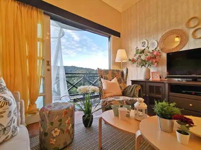 a living room with a large window with a view at Green Hill Apartment in Tanah Rata