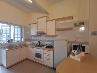 a kitchen with white cabinets and a white refrigerator at Green Hill Apartment in Tanah Rata