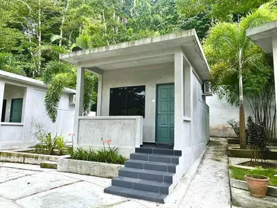 a white house with a blue door and stairs at Pangkor Nature View House in Pangkor
