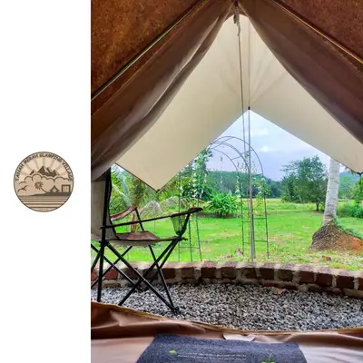 a tent with a chair and a view of a field at Tanah Merah Glamping Village (TMGV) in Kuala Kangsar