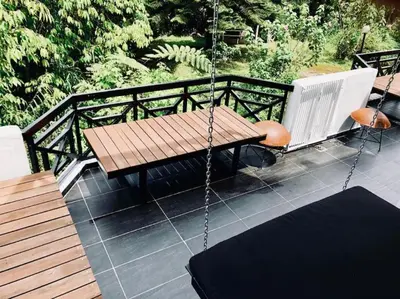 a swing on a balcony with a table and chairs at 80 Colonie Fraser's Hill 16 Pax in Bukit Fraser