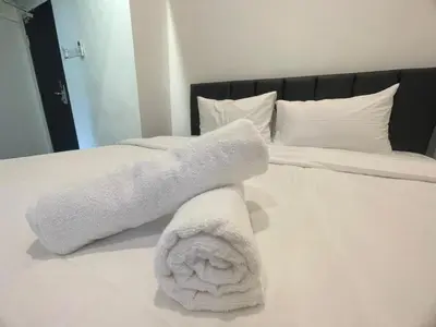 two white towels are stacked on a bed at The Magazine Boutique Hotel in George Town
