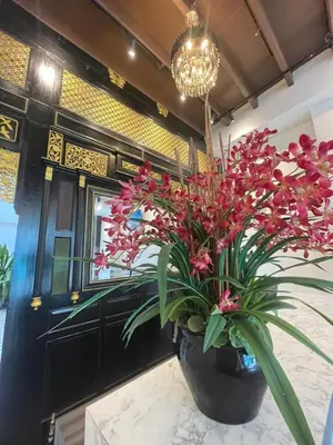 a large vase filled with red flowers on a table at The Magazine Boutique Hotel in George Town
