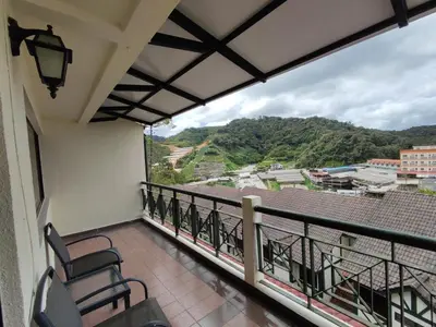 a balcony with chairs and a view of a city at Awesome Homestay Apartment @ Equatorial Hill Resort in Brinchang