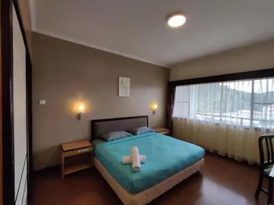 a bedroom with a bed with a cross on it at Awesome Homestay Apartment @ Equatorial Hill Resort in Brinchang