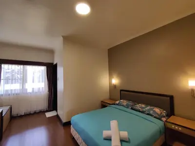 a room with a bed with a cross on it at Awesome Homestay Apartment @ Equatorial Hill Resort in Brinchang