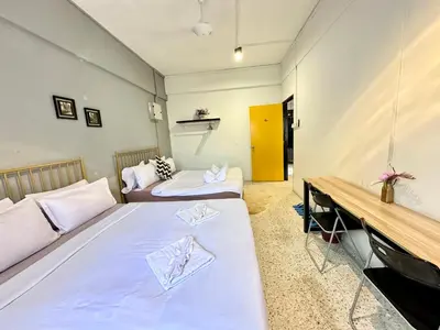 a room with two beds and a bench in it at Mac Inn 94 in George Town