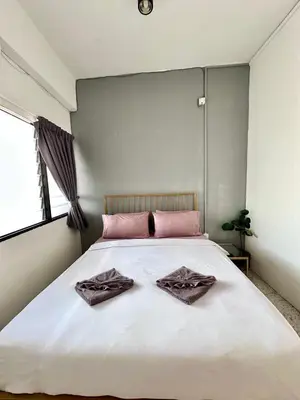 a bedroom with a large white bed with pink pillows at Mac Inn 94 in George Town