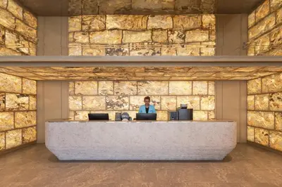 a woman sitting at a reception desk in a brick wall at Citadines Connect Georgetown Penang in George Town