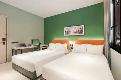 two beds in a room with green walls at Citadines Connect Georgetown Penang in George Town