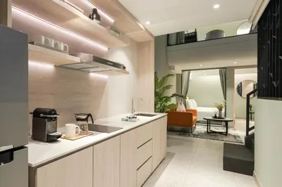 a kitchen with a sink and a living room at Citadines Connect Georgetown Penang in George Town