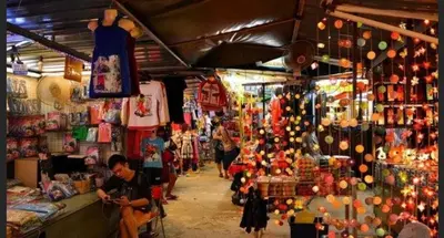 a market with a man sitting in front of a store at Batu Ferringhi Luxury Seaview Suite - 3Br in Batu Ferringhi