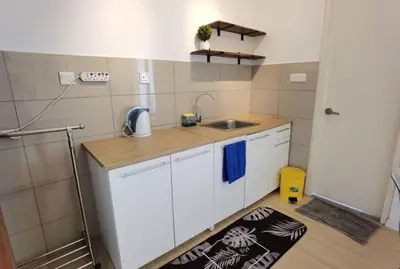 a small kitchen with white cabinets and a sink at Lovers under Cupid's Arrow 丘比特之箭下の恋人 in Butterworth