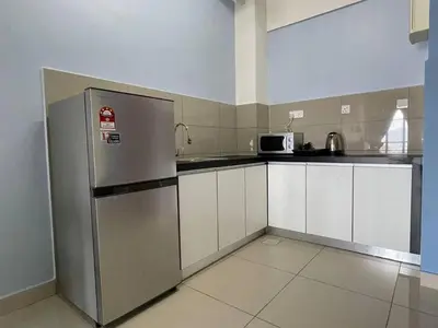 a kitchen with white cabinets and a stainless steel refrigerator at Blue Aesthetic Luxury Seaview 3 min Drive Sunway in Butterworth