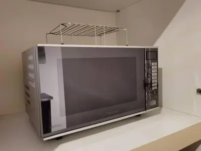 a microwave oven sitting on a shelf in a kitchen at YOU & ME 118 SWEET HOUSE in Tanjong Tokong