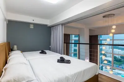 a bedroom with two beds and a large window at 2Bedrooms Maritime Luxury Seaview Suite 2-10pax in Jelutong